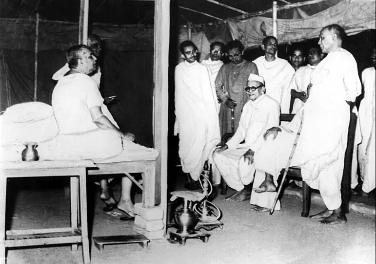 Bihar Finance Minister Dr Anugrah Narayan Sinha seated among devotees during a visit to Sri Sri Thakur Anukulchandra in Deoghar, 1955