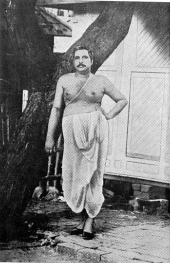 Sri Sri Thakur Anukulchandra standing beneath the Babla tree at Himaitpur, Pabna