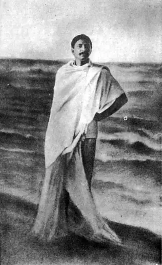 Young Sri Sri Thakur Anukulchandra standing in the sea at Puri, wrapped in a white shawl