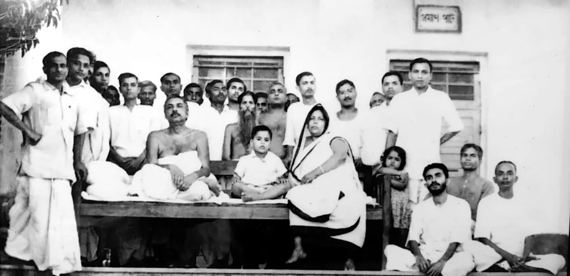 Sri Sri Thakur Anukulchandra seated with Sri Sri Boroma, young Kajalda and disciples at the Pabna Ashram, Himaitpur